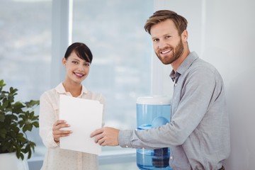 Portrait of smiling executives holding document