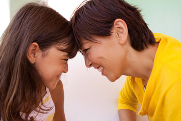 Mother and daughter smiling and telling secrets.