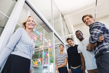 Low angle portrait of business people by plan on glass wall