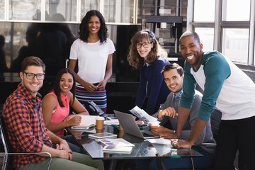 Portrait of smiling colleagues at desk