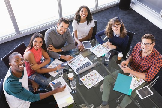 High Angle Portrait Of Business People Sitting At Desk