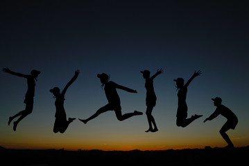 silhouette of  people jumping at sunrise