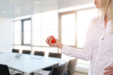 Stress relief concept. Worried and upset business woman trying to calm down with anti stress rubber ball in an office.