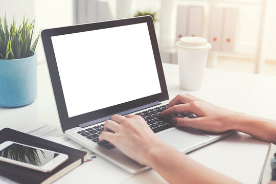 Woman s hands typing on laptop with blank screen