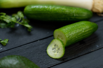 Vegetables ginger lime avocado cut in two pisces cucumber parsley leeks on wooden background