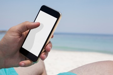 Close up of man using smartphone at beach