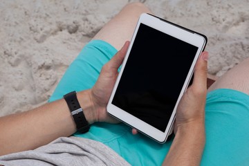 Man using digital tablet on the beach