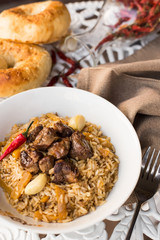 Pilaf - Rice with Meat and Vegetables on the table. Pilaf with lamb and garlic zira
