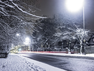 Streaky lights in snowy night time street scene.