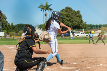 White uniform fast pitch softball batter with eyes in incoming ball.  - obrazy, fototapety, plakaty