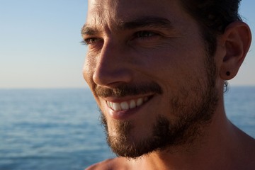 Close up of smiling man looking away at beach