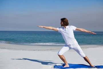 Fototapeta premium Man performing yoga at beach
