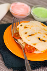 Closeup of a delicious traditional arepas, shredded chicken avocado and cheddar cheese and shredded beef with a mettalic fork