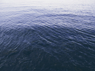 Still sea surface with ripples on clean water. Seawater texture in morning dew.