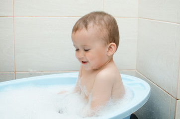Happy baby boy taking a bath