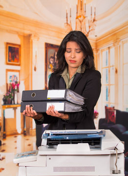 Young Businesswoman Using Copy Machine At The Office