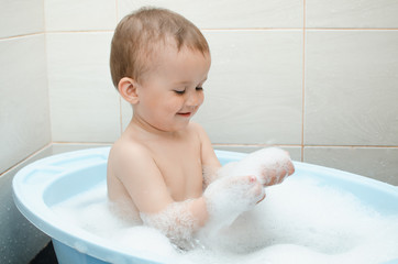 Happy baby boy taking a bath