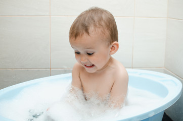 Happy baby boy taking a bath