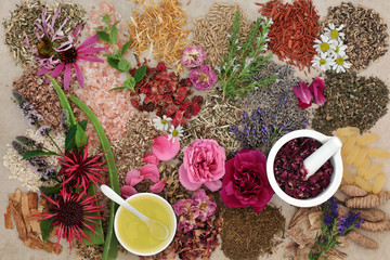 Ingredients for skin care treatment with flower and herb selection, almond oil and rose petals in a...