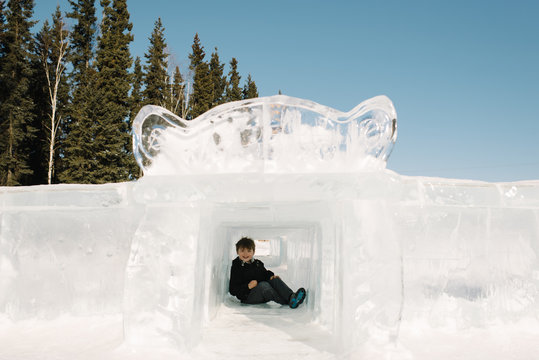Boy sitting in ice sculpture