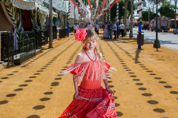 Naklejka premium kobiety w tradycyjnych strojach flamenco tańczą podczas kwietniowych Feria de Abril w Hiszpanii