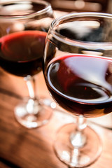 Two glasses of red wine on the vibrant restaurant background. Selective focus.