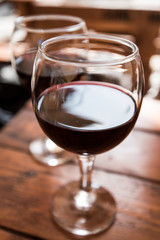 Two glasses of red wine on the vibrant restaurant background. Selective focus.