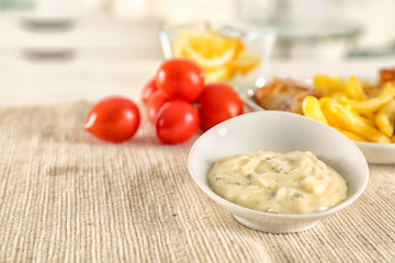 Bowl with tasty mayonnaise sauce on kitchen table