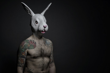 Uomo tatuato con maschera di coniglio