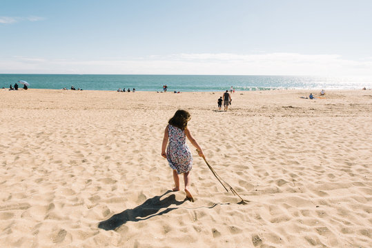 Girl playing with stick on beach