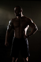 Fototapeta na wymiar Silhouette Bodybuilder Standing In The Gym