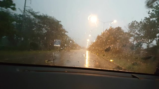 POV front driving a car or vehicle on the road heading to Bangkok in the evening with rain
