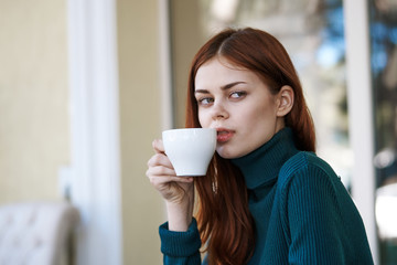 Woman with a cup, morning coffee, building