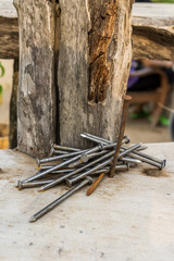 nails / A pile of rusty nails on wooden board.