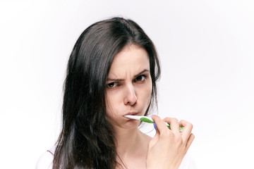 sullen woman brushes teeth