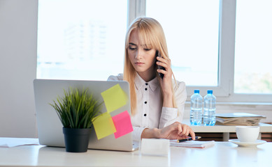 business lady looking in laptop and talking on the phone, colorful notes