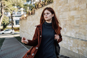 a young lady is walking along the street, autumn season