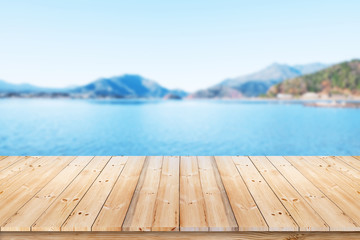 Wood plank with lake and abstract natural green blurred background for product display