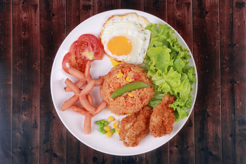 American fried rice topped sunny up,sausage.chicken and herbs
