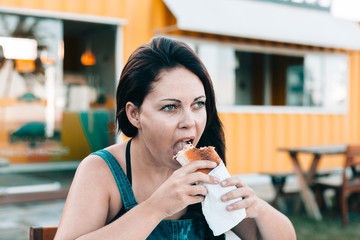 Young woman in outdoor restaurant enjoying her meal