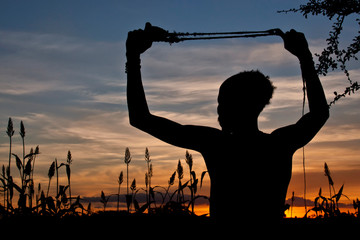 An elder man of the Hamar Tribe with sling shot to scare birds away from his sorghum fields, Omo...