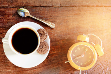 coffee cup and clock on old wood table