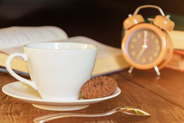 coffee cup and clock on old wood table