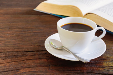 Coffee mug and book on old wooden table