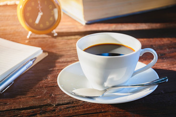 Coffee mug and book on old wooden table