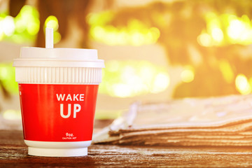 coffee cup clock and news paper on old wooden table