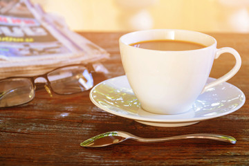 coffee cup clock and news paper on old wooden table
