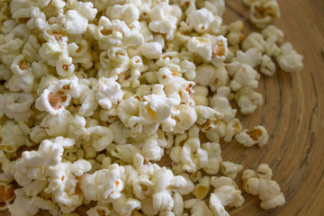 Popcorn in white bowl closeup on wood table