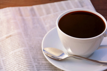 coffee cup clock and news paper on old wooden table