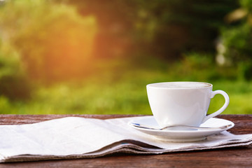 coffee cup clock and news paper on old wooden table